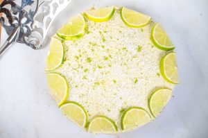 Cashew nut key lime cheesecake with mango and sprinkled desiccated coconut and lime zest