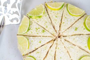 Cashew nut key lime cheesecake with mango and sprinkled desiccated coconut and lime zest