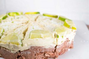 Cashew nut key lime cheesecake with mango and sprinkled desiccated coconut and lime zest