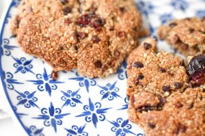 Cinnamon Cranberry Cacao Cookies on blue plate with almond milk