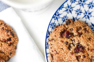 Cinnamon Cranberry Cacao Cookies on blue plate with almond milk