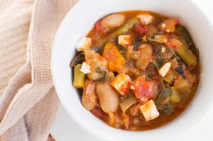 Warming vegetable mediterranean bean feta stew in white dish