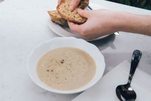 Jerusalem artichoke Soup in white bowl with gluten free bread