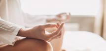 Woman meditating with legs crossed, fingers curled