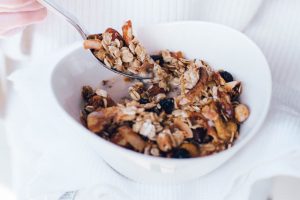 Cherry, banana & coconut flake granola with white towel and cotton