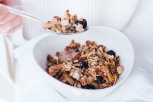 Cherry, banana & coconut flake granola with white towel and cotton