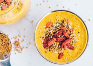 Superfood smoothie turmeric ginger goji berries on white marble.